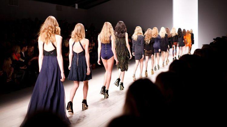 models walking on the catwalk in front of a crowd