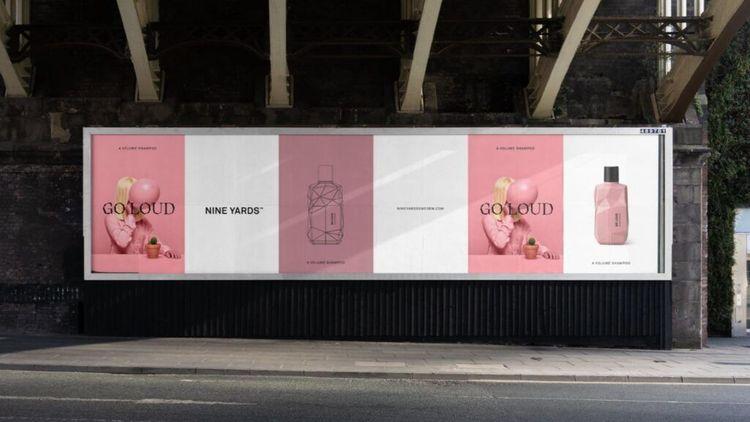 Pink and white street advertisement showing Nine Yards haricare products