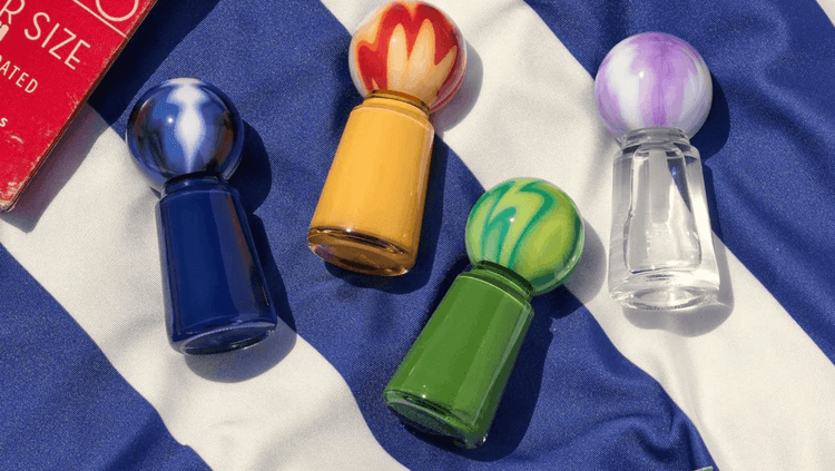 nail varnish bottles on a striped blue and white rug