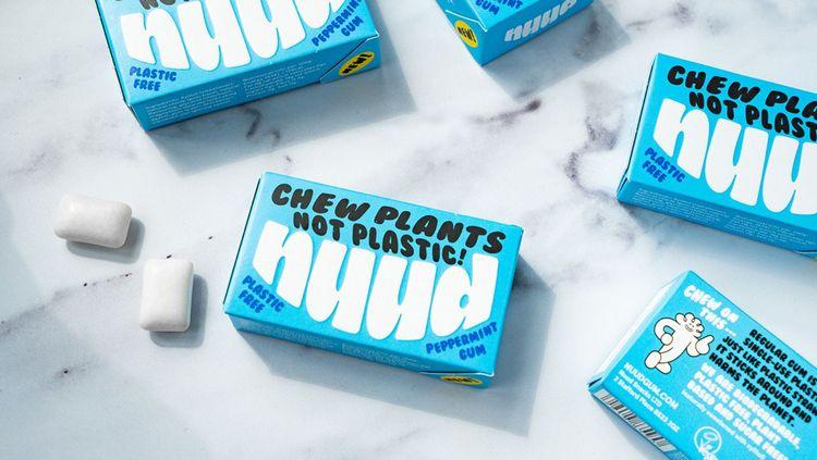 bright blue cardboard packets of Nuud gum on a marble surface with the words chew plants not plastic