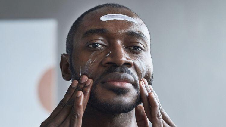 Man massaging vegan skincare products into his face