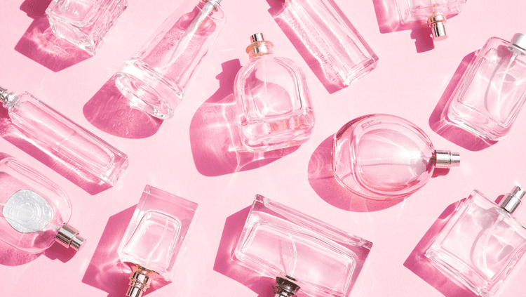 Bottles by vegan perfume brands on a pink background