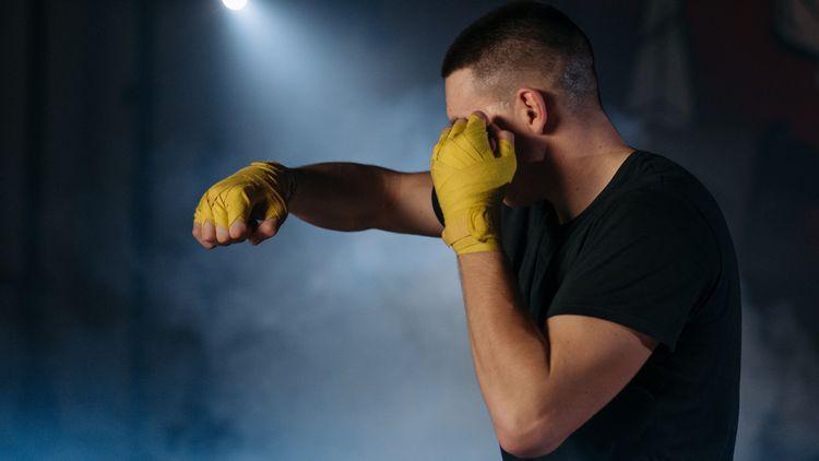  Man practising Mixed martial arts (MMA) in a dark, smoky room