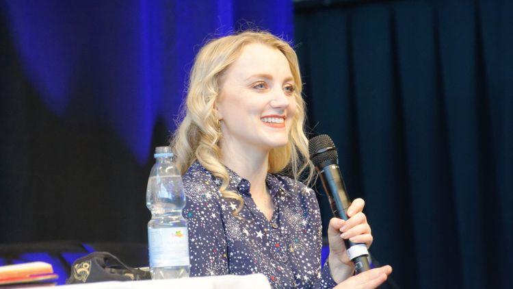Image of smiling woman (Evanna Lynch) holding a microphone
