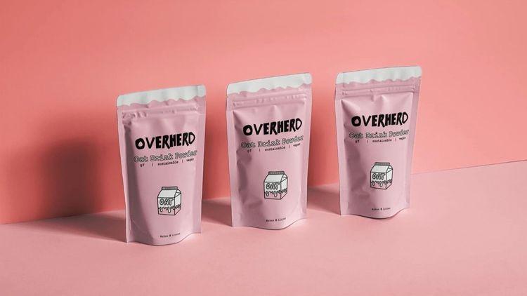 Three pink packs of Overherd’s oat milk powder