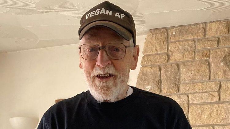 Paul Youd smiling with a baseball cap on with ‘Vegan AF’ spelled out on the cap
