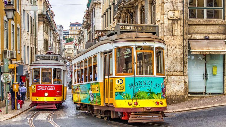 Two of Lisbon’s iconic yellow trams travelling besides one another