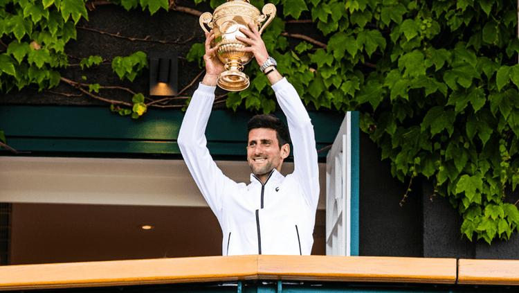 Novak Djokovic holding Wimbledon trophy over his head